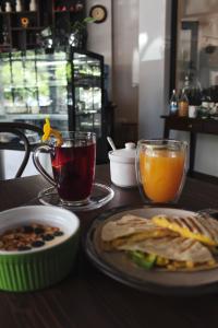 a table with a plate of food and two glasses of juice at Kunan Hotel in Cochabamba