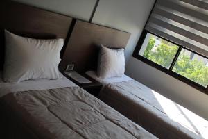 a hotel room with two beds and a window at Kunan Hotel in Cochabamba