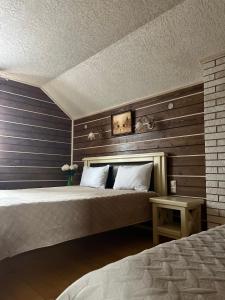 - une chambre avec un grand lit et un mur en bois dans l'établissement Aura Karpat, à Bukovel