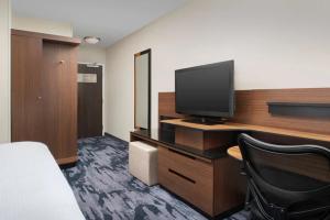 Pokój z biurkiem, telewizorem i krzesłem w obiekcie Fairfield Inn & Suites Baltimore BWI Airport w mieście Linthicum Heights