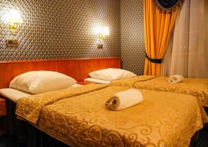 two beds in a hotel room with towels on them at Szafir in Rzeszów