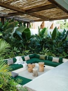 een woonkamer met een groene bank en een aantal planten bij Tias Villas in Kuta Lombok