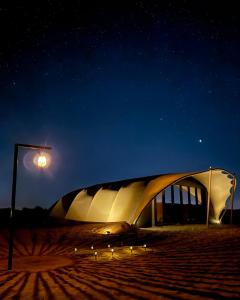 un edificio de noche con luz de la calle en La Duna Desert Camp, en Shāhiq