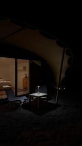 Habitación con mesa, silla y cama en La Duna Desert Camp, en Shāhiq