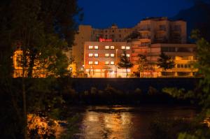 una ciudad por la noche con un río y edificios en ibis Grenoble Gare, en Grenoble