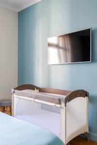 - une chambre avec un lit et une télévision murale dans l'établissement Les chambres du Graoully - Le 109 - Metz Gare - Parking inclus - NO S-model, à Metz