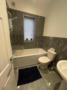 e bagno con vasca, servizi igienici e lavandino. di Spacious 2 bedroom apartment a Liverpool