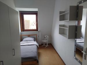 a small room with two beds and a window at Monteurzimmer bei der Gärtnerei in Grünendeich