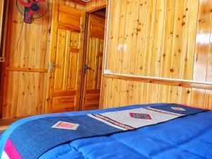 a bedroom with a bed in a wooden cabin at Peace Home in Sa Pa