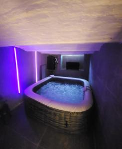 a room with a large tub with purple lighting at My house jacuzzi Billiards in Brussels