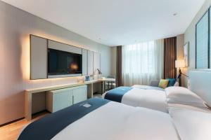 A bed or beds in a room at Echarm Hotel Guangzhou Panyu Shiqiao Subway Store