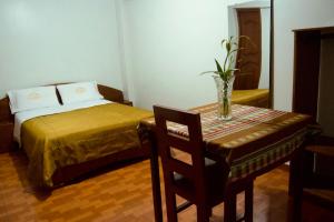 - une chambre avec un lit et une table avec une chaise dans l'établissement Hotel California, à Chachapoyas