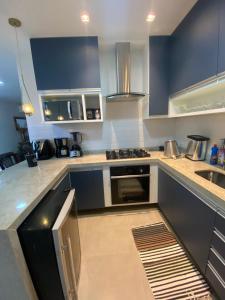 a kitchen with blue cabinets and a stove top oven at Casa de praia in Paraty