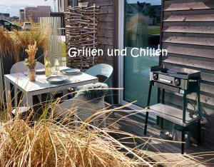 a patio with a grill and a table and chairs at Hafensuite iPURA VIDA! - für Leben-Genießer in Kappeln