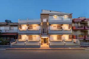 un gran edificio de apartamentos con luces encendidas en Villa Zoe on the beach, en Sarti