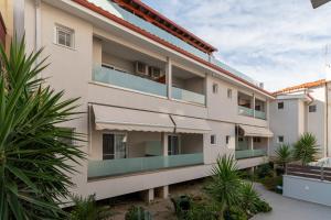 un edificio de apartamentos con balcones y plantas en Villa Zoe on the beach, en Sarti