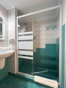 a glass shower in a bathroom with a sink at HOTEL DUNĂREA in Mamaia