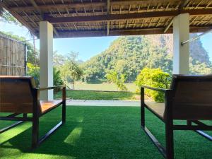 um alpendre com duas cadeiras e vista para uma montanha em Meexok guesthouse em Nongkhiaw