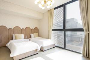 um quarto com 2 camas e uma grande janela em Silk Valley - Gorgeous 4b Maid Near Al Hamriyah em Sharjah