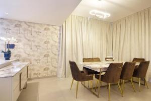 uma sala de jantar com mesa e cadeiras em Silk Valley - Gorgeous 4b Maid Near Al Hamriyah em Sharjah