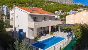 A piscina localizada em Villa Leonore in Omis with 4 en-suite bedrooms, heated pool, PS5, completely fenced yard & just 3min walk from sandy beach ou nos arredores