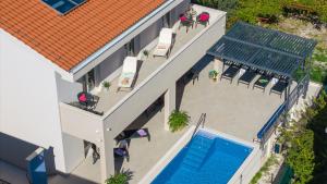 A piscina localizada em Villa Leonore in Omis with 4 en-suite bedrooms, heated pool, PS5, completely fenced yard & just 3min walk from sandy beach ou nos arredores