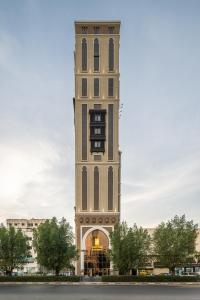 een hoog gebouw met een klokkentoren in een stad bij Elaf Qinwan Hotel in Mekka