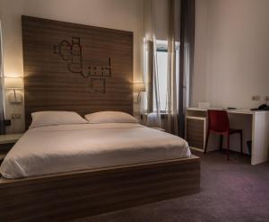 a bedroom with a large bed with a wooden headboard at Slavija Culture Heritage Hotel in Split