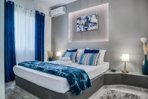 a bedroom with a large bed with a blue blanket on it at MarGio Bay in Limenas