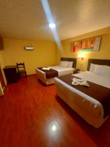 um quarto de hotel com duas camas e uma cadeira em Casona Plaza Hotel Centro em Puno