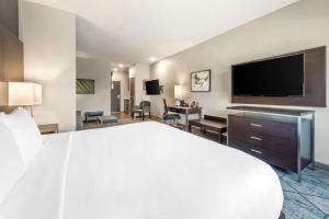 una camera con un grande letto e una TV a schermo piatto di Comfort Inn & Suites a Clarksville