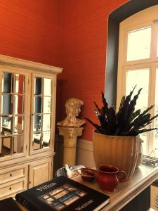 une table avec un livre et un vase avec une plante dans l'établissement Hotel Villa Hentzel, à Weimar