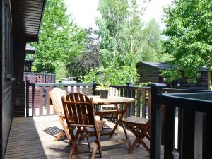 een terras met een tafel en stoelen bij Fern Lodge- Burnside Park in Keswick