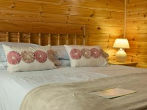 een slaapkamer met een bed met kussens erop bij Fern Lodge- Burnside Park in Keswick