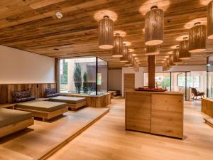 una sala de estar con techos de madera y ventanas grandes. en Hotel Sonnschein, en Niederau