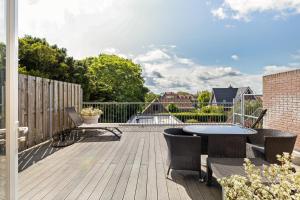 eine Terrasse mit einem Tisch und Stühlen auf einer Terrasse in der Unterkunft De Lijsterhof in Domburg