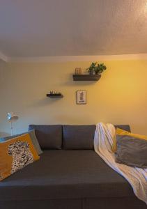 een woonkamer met een bank en een gele muur bij LATE ESCAPE DEAL ZUM JAHRESWECHSEL - Gemütliches Studio unterm Dach mit Blick über Kinzigtal in Gelnhausen