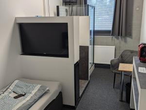 a room with a large flat screen tv on a wall at Business-Motel, free XL-Parking, WiFi, massage-chairs, sauna, shared kitchen, breakfast 2go, free soda, coffee in Heimsheim