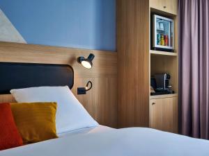 um quarto com uma cama com uma luz na cabeceira em Mercure Paris Gare De Lyon TGV em Paris