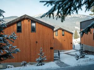 un edificio arancione con neve per terra di Phoenix Relax Park a Bukovel