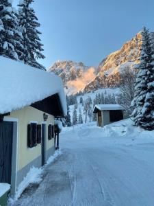 uma casa coberta de neve ao lado de uma estrada em Appartementhaus Hochkönig - Panoramablick em Mühlbach am Hochkönig