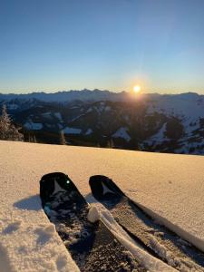 um snowboard sentado no topo de uma montanha coberta de neve em Appartementhaus Hochkönig - Panoramablick em Mühlbach am Hochkönig