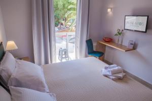 um quarto de hotel com uma cama e uma janela em Anemos Rooms & Apartments em Nafplio