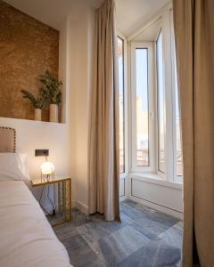 a bedroom with a bed and a large window at William Martin Apartments in Huelva