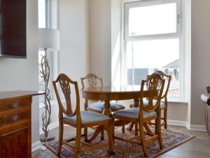 d'une table à manger, de chaises et d'une fenêtre. dans l'établissement Inver House Apartment, à Inverurie