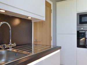 La cuisine est équipée d'un évier et d'un four micro-ondes. dans l'établissement Inver House Apartment, à Inverurie