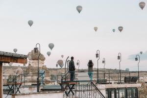 um grupo de pessoas olhando para balões de ar quente em Turan Cappadocia Cave em Goreme