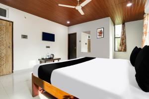 - une chambre avec un lit blanc et un plafond en bois dans l'établissement Super Hotel O Madhapur VIP Hills, à Hyderabad