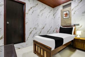 - une chambre avec un lit et un mur en marbre dans l'établissement Super Hotel O Madhapur VIP Hills, à Hyderabad