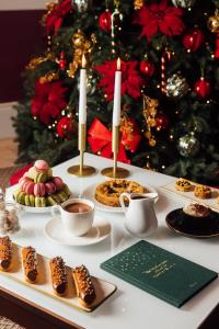 una mesa con galletas y tazas de café y un árbol de Navidad en Hôtel Barrière Le Normandy, en Deauville